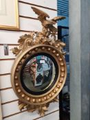 A gilt convex wall mirror having Eagle surmount