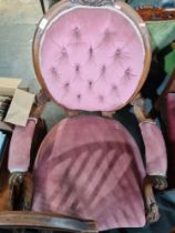 A Victorian carved Walnut open armchair with button back