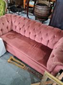 An old Chesterfield sofa with pink Draylon cover