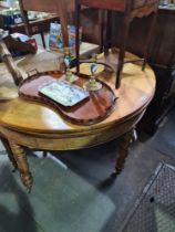 An antique French Walnut demi lune foldover table, bow fronted on turned legs