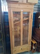 An old French pine cupboard having glazed door with drawer below, 84cm