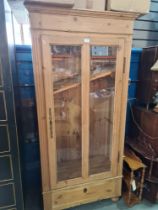 An old French pine cupboard having glazed door with drawer below, 84cm