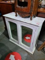 A white painted hanging cupboard having 2 mirror doors