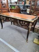 A 19th Century French ebony desk, having three front drawers with gilt metal mounts on cabriole