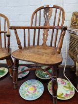 A Windsor style child's chair with carved out seat and support stretchers