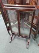 A Regency mahogany screen having centred glass panel, with two smaller folding panels