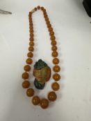 String of knotted graduating circular amber beads, each separated with a clear bead, and a 1930/40s