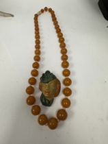 String of knotted graduating circular amber beads, each separated with a clear bead, and a 1930/40s