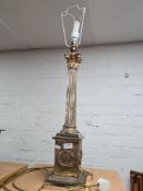 A silver plated Corinthian column style lamp, with laurel wreath design to the base