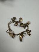 9ct yellow gold charm bracelet hung with approx 15 9ct yellow gold charms to incl. boat, thimble, el