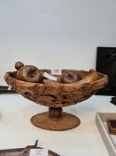 An antique carved fruitwood oval pedestal bowl, decorated leaves and sundry wooden fruit