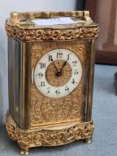 A French brass carriage clock having floral and scroll decoration