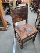 A set of eight matching leather and brass studded chairs with carved lion decorations