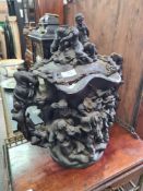 An antique carved oak two handled urn decorated figures around tree, the interior and lid lined with