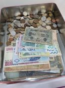 A tin of mixed World coinage and bank notes