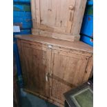 A large stripped pine corner cupboard on plinth base