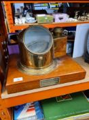 An old brass binnacle compass on oblong wooden base and presentation plaques