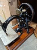 An antique sewing machine by Willcox and Gibbs, in a stained pine case