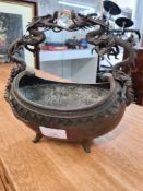 An Oriental metal oval bowl having bronze dragon handle with glass ball, 22cm