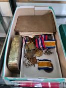 A selection of World War I and World War II medals, badges, ration books, etc