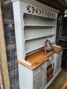 A Welsh dresser with a painted base and plate rack, shabby chic style