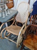 A vintage Dinette bentwood and cane upholstered rocking armchair
