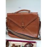 A modern tan leather satchel with shoulder strap, having internal Mulberry label