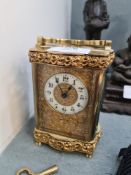 A French brass carriage clock having floral and scroll decoration