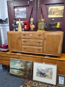 An Ercol elm sideboard having three central drawers, 155cms