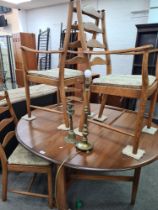 A modern Ercol two flap dining table and a set of four matching chairs, two of which have arms