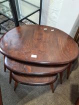 A nest of Ercol pebble coffee tables (3), having dark stained finish