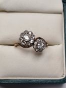 Early 20th Century crossover design ring comprising two crossing diamonds inset daisy heads, one rub