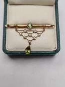 9ct yellow gold brooch with bamboo bar brooch with round cut peridot, suspended with triangular open