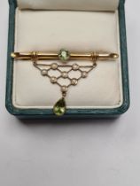 9ct yellow gold brooch with bamboo bar brooch with round cut peridot, suspended with triangular open