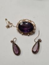 Antique 15ct yellow gold brooch with large mixed cut oval amethyst with scrolling 15ct gold frame se