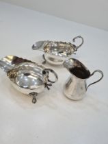 A pair of silver creamers, having scallop design rim, acanthus leaf handle, and embossed feet hallma