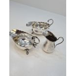 A pair of silver creamers, having scallop design rim, acanthus leaf handle, and embossed feet hallma