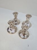 Two pairs of miniature candlesticks, one having raised circular pedestal bases, Birmingham 1973, San