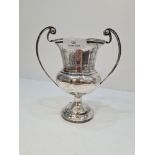 A silver trophy cup of baluster form, having two handles, raised pedestal base and engraved name bod