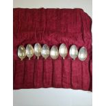 A set of eight silver teaspoons having heavily embossed bordered handles of floreated and foliate de