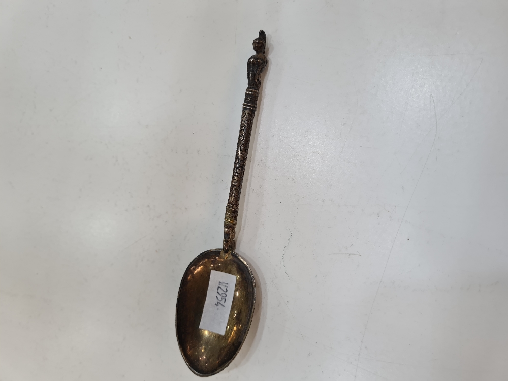 A Victorian silver spoon having ornate handle terminating with a figure on the finial. Engraved and
