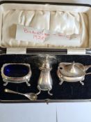 A cased silver cruet set hallmarked Birmingham 1928, Docker and Burn Ltd., with Bristol Blue insets,