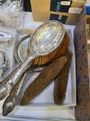 A silver backed dressing table set having ornate details of embossed swags and floreated decoration.