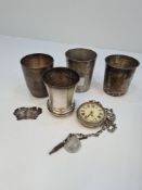 White metal cups with various marks on the bases, a silver decanter label and a silver cup by Philip