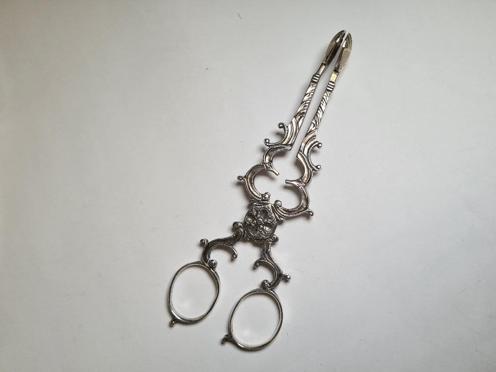 A pair of pretty Irish silver tongs having ornate details, shell ends and scroll handles. Only one m