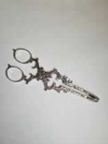 A pair of pretty Irish silver tongs having ornate details, shell ends and scroll handles. Only one m