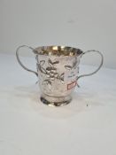 A large Georgian silver two handled cup having gilt interior and embossed body of flowers, in low re