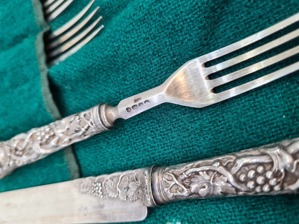 A set of six Victorian silver fruit knives and forks, with heavily embossed handles of vines and gra - Image 2 of 6