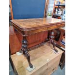 A late Victorian burr walnut foldover card table having carved supports & stretcher