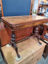 A late Victorian burr walnut foldover card table having carved supports & stretcher